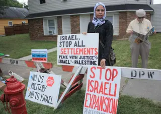 Lana Hijazi, a graduate student in the College of Visual and Performing Arts, calls for peace between Israel and Palestine on the corner of Robinson Street and Teall Avenue near Henninger High School.