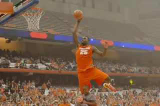 Rakeem Christmas, a late entry in the dunk contest, soars over the sons of assistant coaches Mike Hopkins and Adrian Autry.