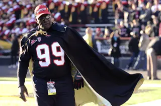 A fan storms the sideline with an extravagant cape. 