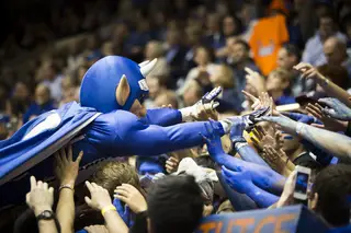 Duke's mascot gets passed from the court to the top of the student section.