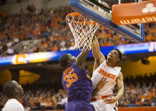 Michael Gbinije tries to dunk over Landry Nnoko's outstretched arm. 