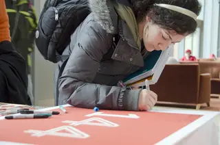 Tania Nsouli, junior computer engineering signs a 144th birthday  card. “I walked into the Life Sciences building and they told me it was Syracuse’s birthday, so I made sure I wished it a happy one.”   