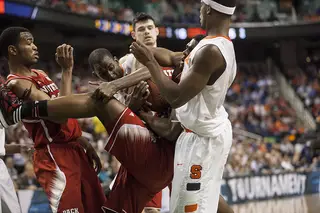 A crowd of Syracuse and N.C. State players fight for a loose ball. 