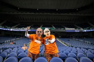 Two Syracuse fans show support in an empty stadium way before tipoff at 7 p.m.
