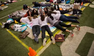 Members of the club softball team huddle around a blanket chatting early on in the evening. 