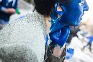 Greg Bunce, a sophomore Mechanical Engineering student, wipes blue paint on his neck before Saturday night's game.