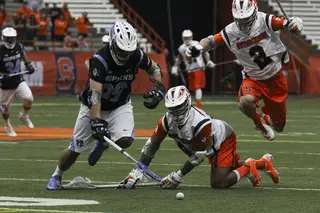 Rice pounces over Syracuse midfielder Hakeem Lecky to go for the ground ball.