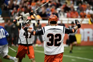 Midfielder Tom Grimm raises his arms as Joe Gillis, who scored his second goal of the season, puts his stick above his head.
