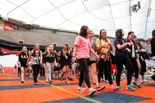 Relayers walk around the Carrier Dome during Relay For Life, which lasts overnight from Saturday into Sunday.