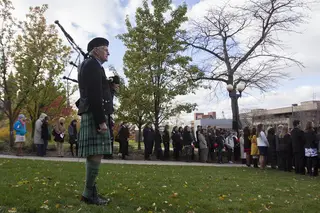 A bagpipe player performs at the Rose Laying Ceremony at the Remembrance Wall on Friday.
