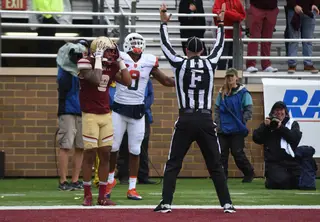 Ishmael celebrates a touchdown catch, a Boston College defender holds his hands on his head and a referee signals the call.