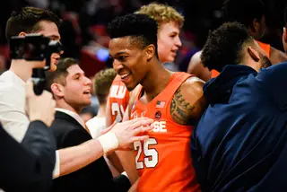 Battle pushes through a crowd of happy Syracuse players after the win.
