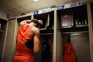 Chukwu scrolls through his phone beside his locker, grappling with the season-ending loss.