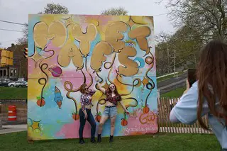 SU freshmen Alyssa Grzesiowski and Cheyene Muenzel pose in front of the Mayfest mural.