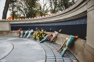 The flowers of the public lay against the Remembrance Wall.