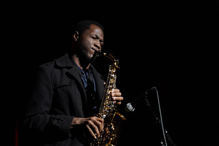 The saxophonist, who goes by the name of Daniel, plays a song on his alto saxophone in accompaniment with an African beat.