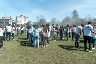 A crowd of students gather to connect, throw powder at one another, and celebrate Holi together.