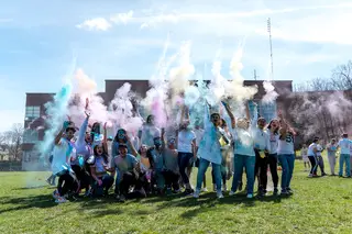 A group of students gathered together to throw colored powder in the air to celebrate the occasion.
