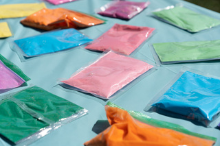Packets of colored powder are left at a central table for attendees to use for throwing powder at one another.