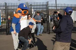 Fans pose with the Syracuse Mets mascot Scooch for a photo before the game begins. 