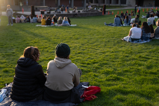 Students sit on blankets on ESF's quad as they listen to Flannel Channel perform.
