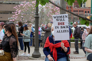 Protestors hold signs describing the implications of making abortions illegal in some states. 