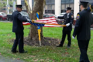 Officers from the Syracuse Police Department fold an American flag after a memorial service in remembrance of the victims of the 9/11 attacks. 