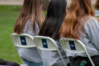 The Remembrance Scholars sit in chairs labeled with numbers corresponding to the Pan Am Flight 103 seat numbers of the students they represent. The cohort sat in silence for the duration of the event.