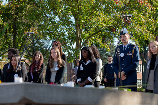 After placing a rose on the wall, Remembrance Scholars take their place behind it as the other student victims' names are read. The cohort waited silently as the only sounds surrounding the wall were the kind words spoken about those honored. 