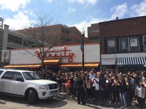 A crowd stands outside Varsity Pizza near the SU campus Friday. Former Secretary of State and Democratic frontrunner for president Hillary Clinton stopped at the establishment for lunch.