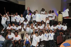 Jim Boeheim poses with a group of children at the Boys & Girls Club of Syracuse.
