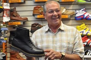 John Vavalo, owner of J. Michael Shoes, holds a shoe inside his store, which relocated into its Marshall Street store in June. A January 21st pipe burst caused flood damage to the basement
