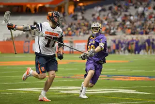 Schoonmaker holds his stick out wide as Albany's Eric Cantor tries to poke the ball away.