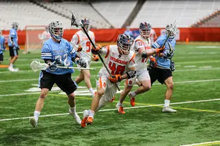 Jared Fernandez rushes through multiple Johns Hopkins players. The Orange started to win a majority of its faceoff opportunities after Fernandez was inserted on the wing opposite Kennedy.