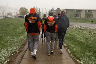 SU athletes on the men's cross country team, each wearing their own One Orange T-shirt, march together in support of Black athletes, administrators, coaches and students.