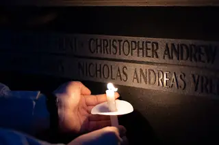 A Remembrance Scholar holds their candle to light up one of the student's names. 
