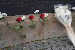 Roses and flowers rest against the Wall of Remembrance after the Rose-Laying Ceremony.