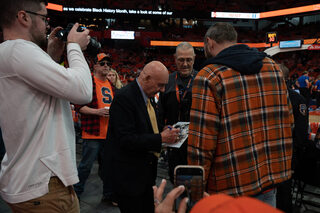 Basketball sportscaster Dick Vitale signs autographs for fans as he moves through the crowd on his way to his seat. Vitale was among the notable guests in attendance at the game. 