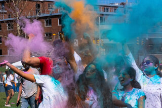 Bright turquoise, tangerine and magenta powders fly through the air (at the Women’s Building Field).