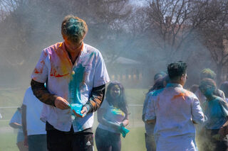 Attendees leave the Holi celebration covered in yellow, red, blue and purple powders.